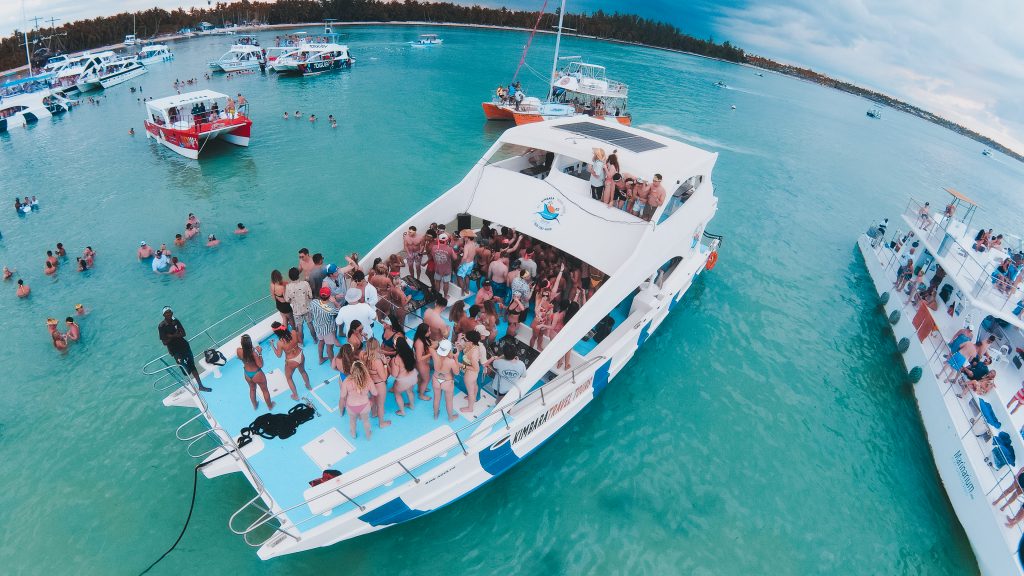 a group of people standing on a boat in the water.